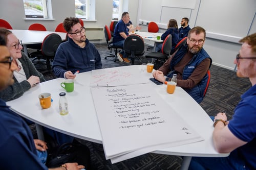 The outserve team sit around and discuss a project